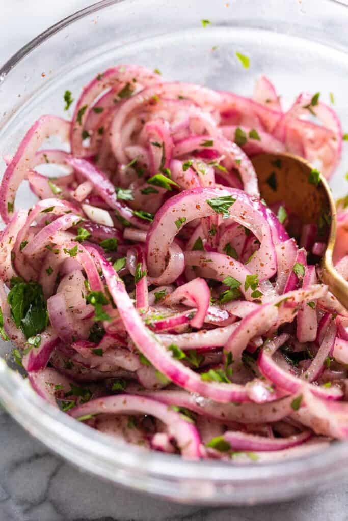 thinly sliced red onion mixed with parsley and sumac