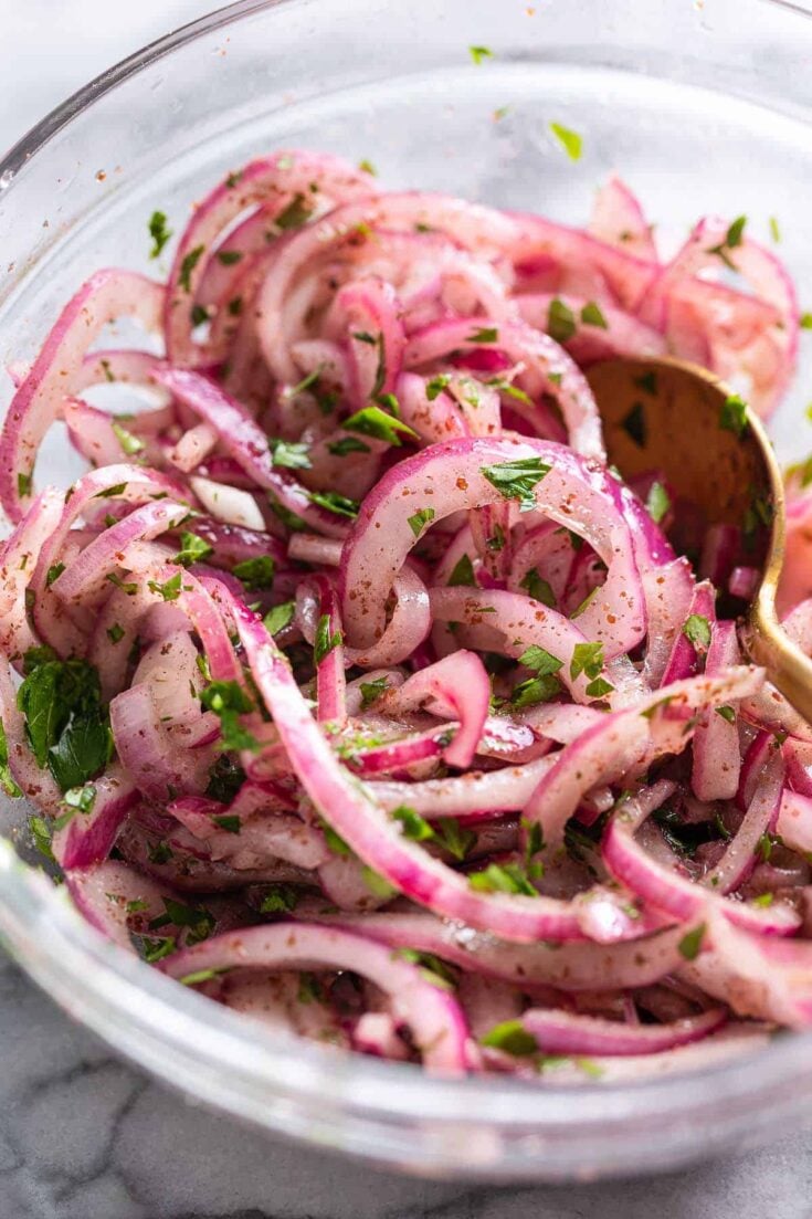 a bowl of thinly Sumac Onions - thinly sliced red onions mixed with sumac and parsley