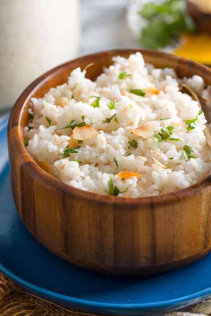 Toasted Coconut Rice with toasted coconut flakes and cilantro topping the bowl