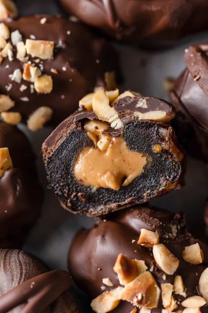 a chocolate covered medjool date cut in half to show off the peanut butter filling