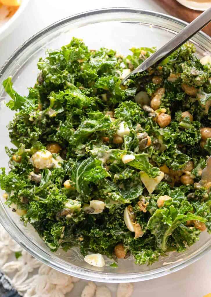 kale salad with chopped hard boiled egg and chickpeas mixed with a creamy dressing