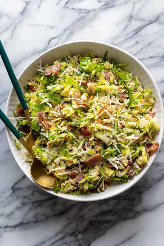 a Bacon and Brussels Sprout Salad in a bowl with serving spoons