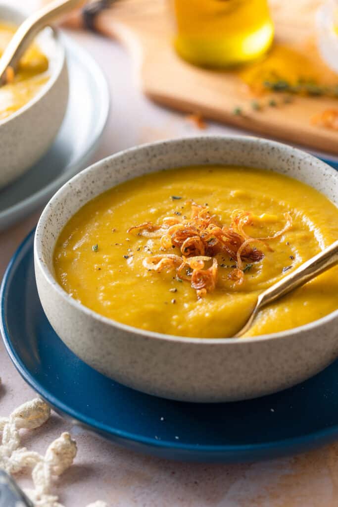 Roasted Acorn Squash Soup in a soup bowl with crispy shallots