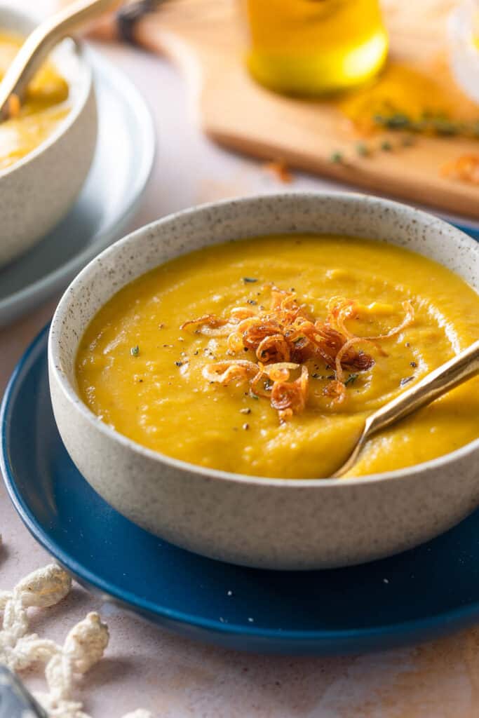 Roasted Acorn Squash Soup in a soup bowl with crispy shallots