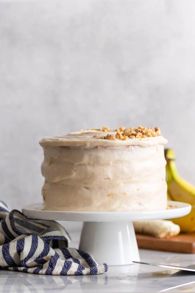 a Gluten Free Banana Cake & Cream Cheese Frosting on a cake stand