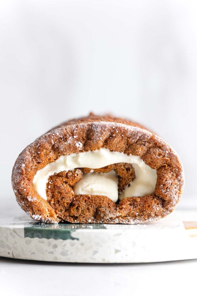Gluten Free Pumpkin Roll on a cutting board filled with a cream cheese filling