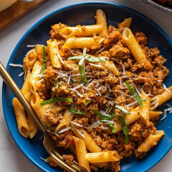 pork ragu on a plate with fresh basil and parmesan