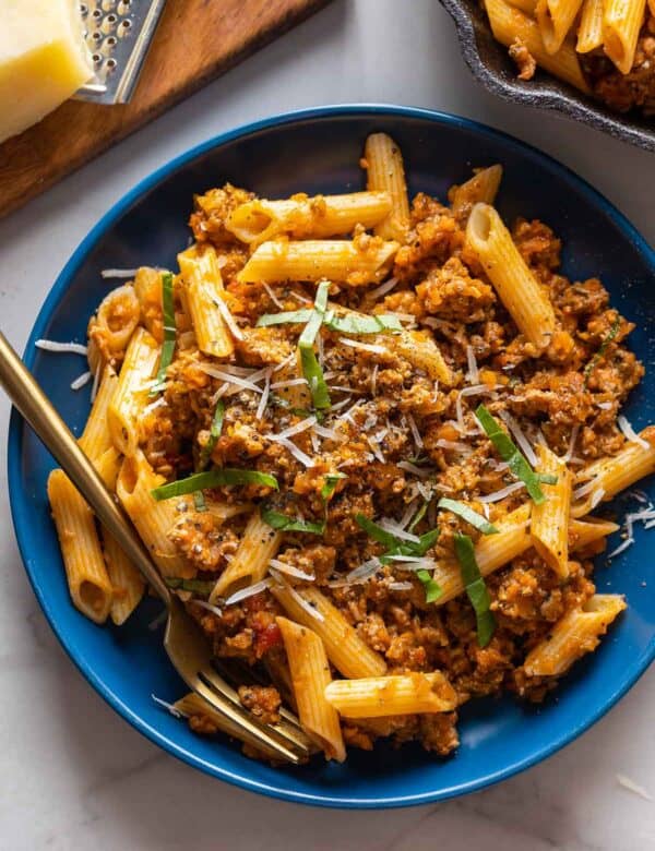 pork ragu on a plate with fresh basil and parmesan