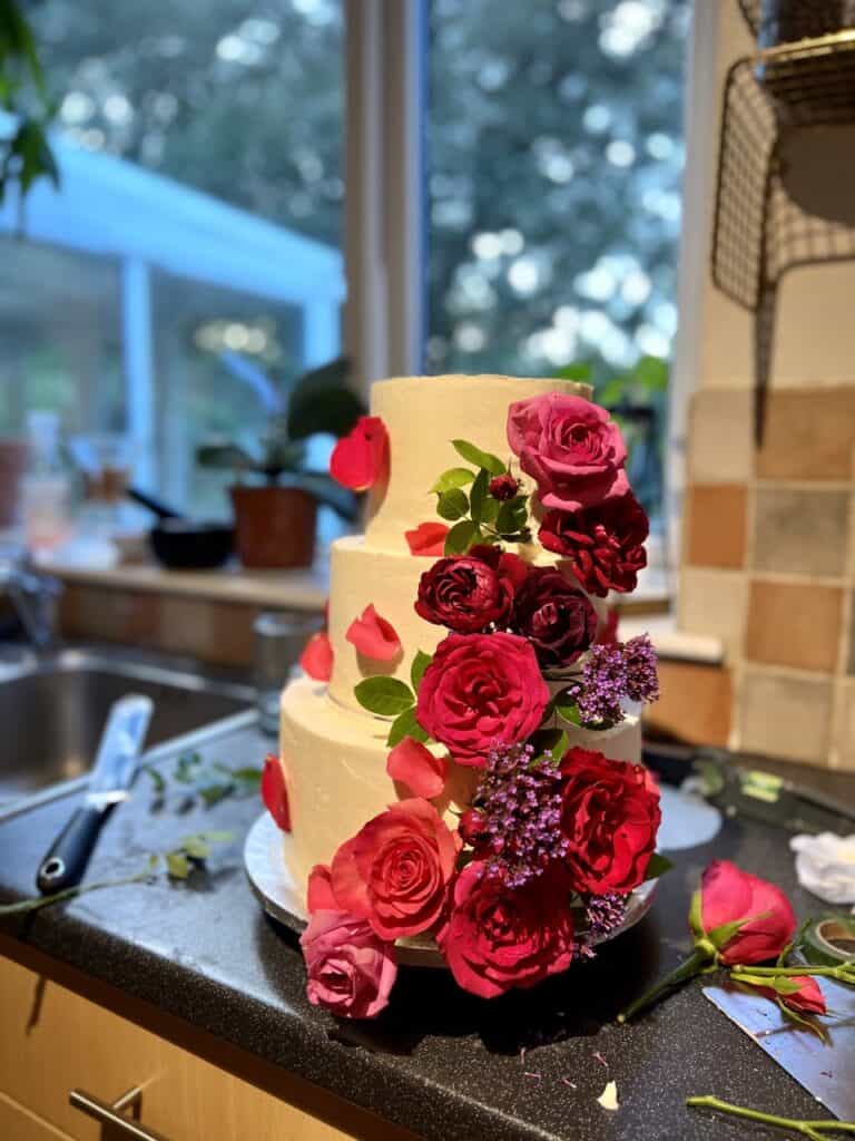 a 3-tier wedding cake decorated with fresh flowers