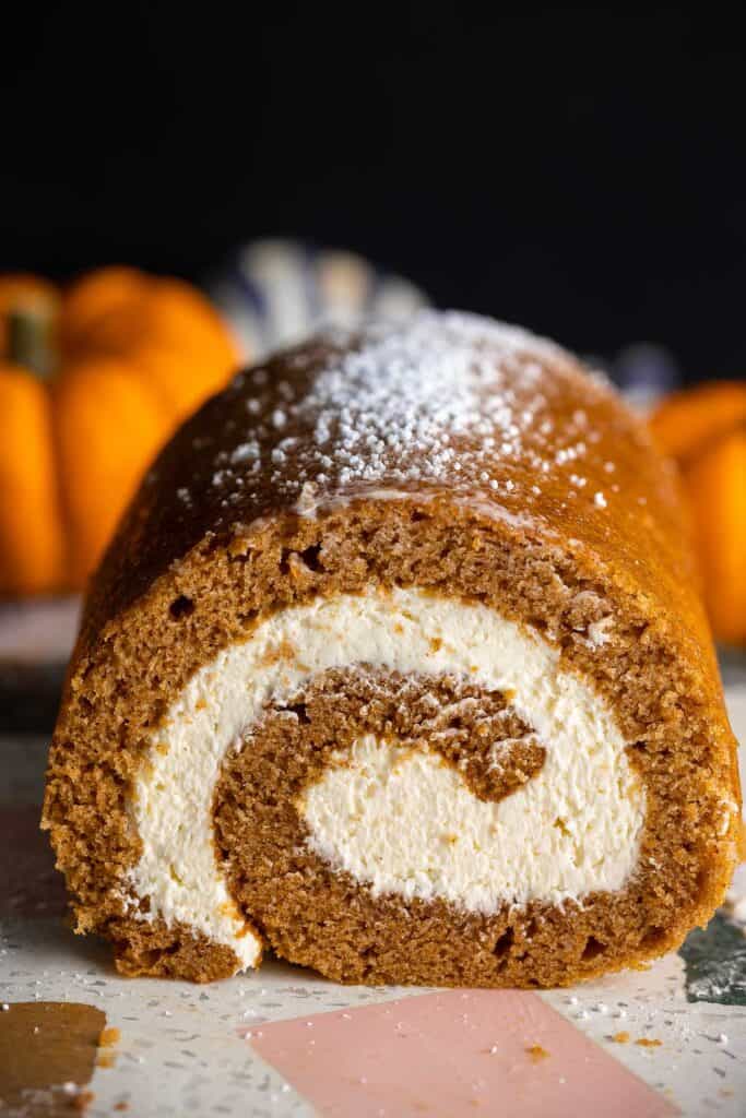 Gluten Free Pumpkin Roll & Whipped Cream Cheese Frosting dusted with powdered sugar on a serving platter