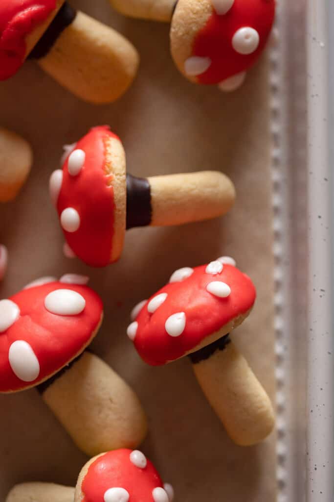 sugar cookies in the shape of toadstool mushrooms on a baking sheet