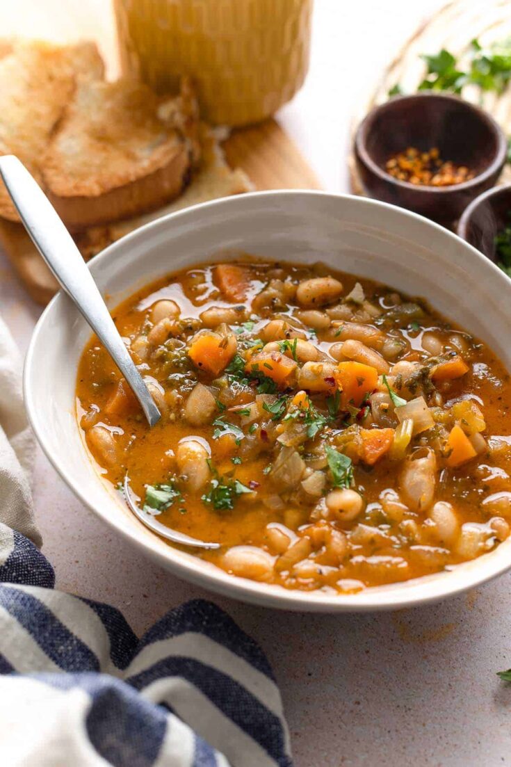 fasolada soup topped with fresh parsley and chili flakes