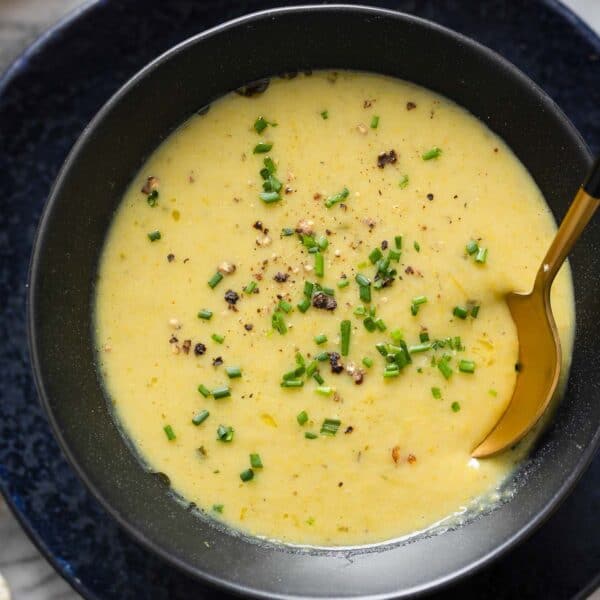 Asparagus Potato Soup in a bowl with a spoon topped with fresh chives