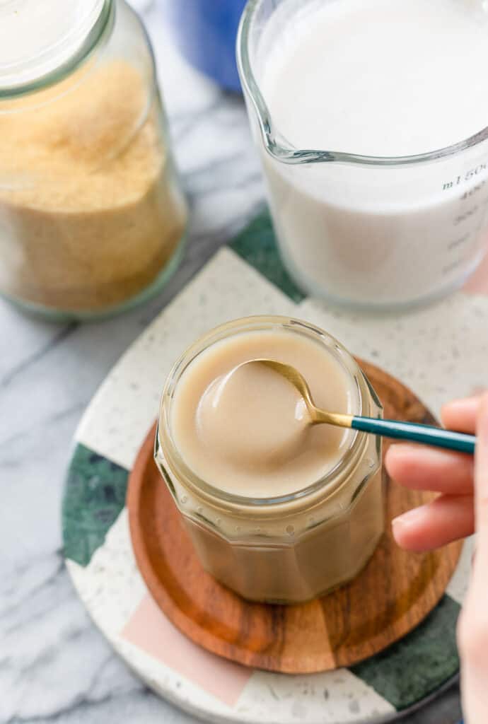 homemade condensed milk made from coconut milk in a jar with spoon