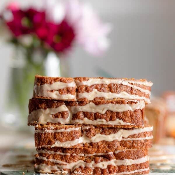 4 slices of glazed paleo carrot cake loaf stacked on top of each other