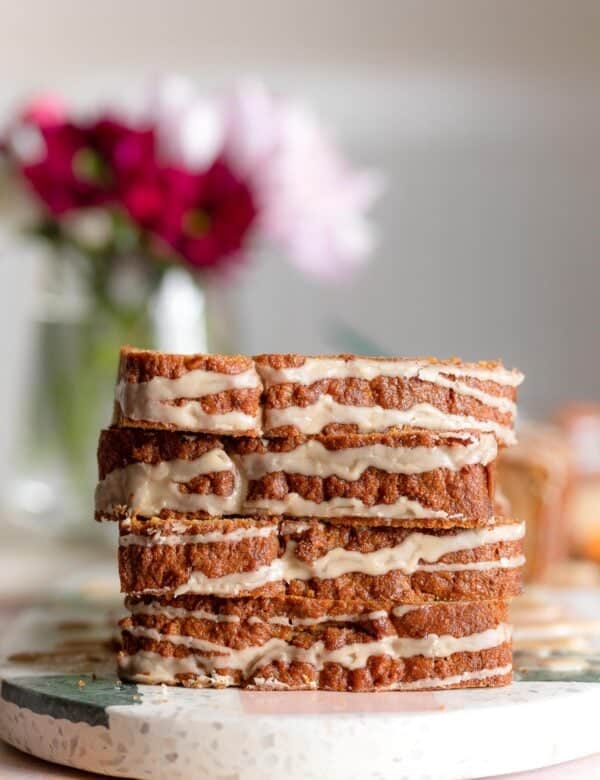 4 slices of glazed paleo carrot cake loaf stacked on top of each other