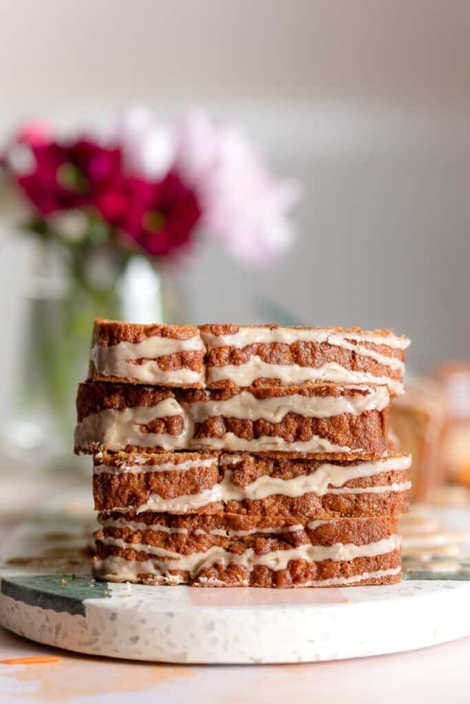 4 slices of glazed paleo carrot cake loaf stacked on top of each other