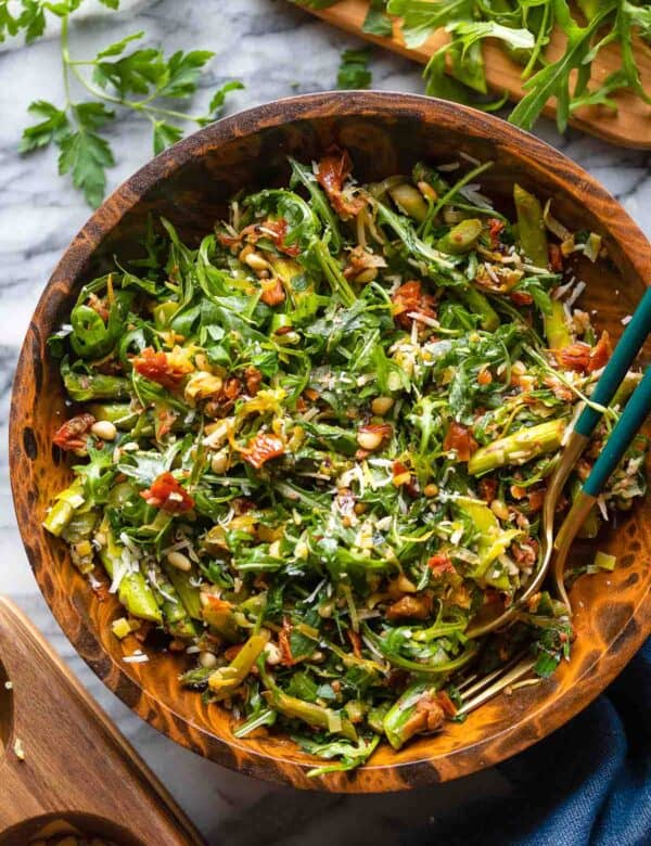 Sautéed Asparagus Salad with Sun-Dried Tomato in a big salad bowl with a couple of serving forks