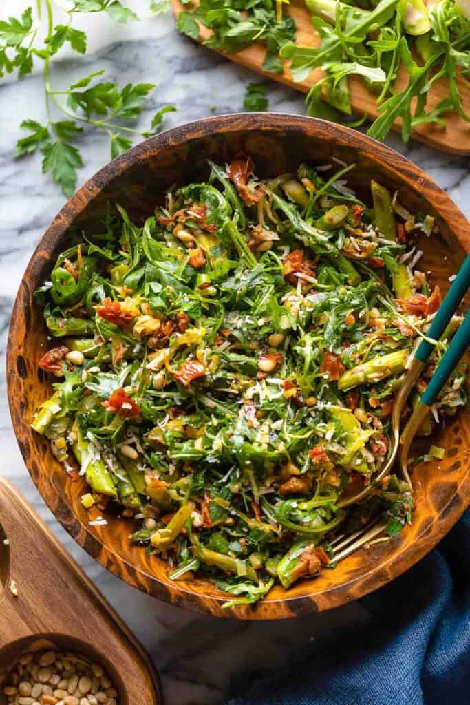 Sautéed Asparagus Salad with Sun-Dried Tomato in a big salad bowl with a couple of serving forks