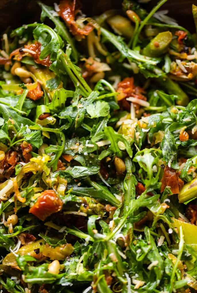 an asparagus salad with sun dried tomatoes, Italian parsley, arugula, asparagus, grated parmesan, and lemon zest