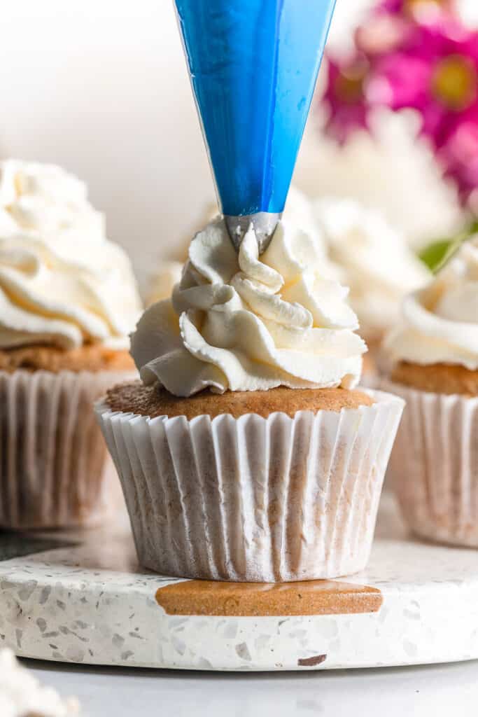 a cinnamon cupcake with whipped mascarpone frosting piped on top with a 2D piping tip