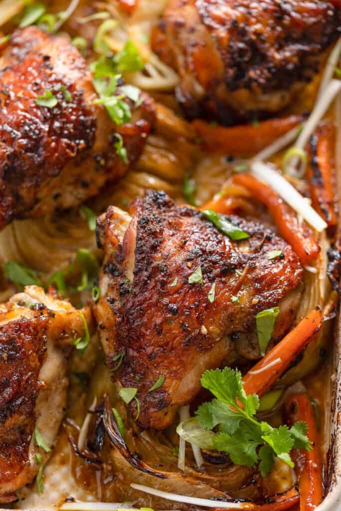 five spice chicken thighs over roasted carrot slices and cabbage wedges