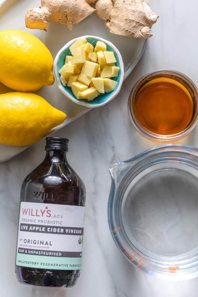 ingredients needed for making homemade switchel: apple cider vinegar, water, lemon, ginger and maple syrup