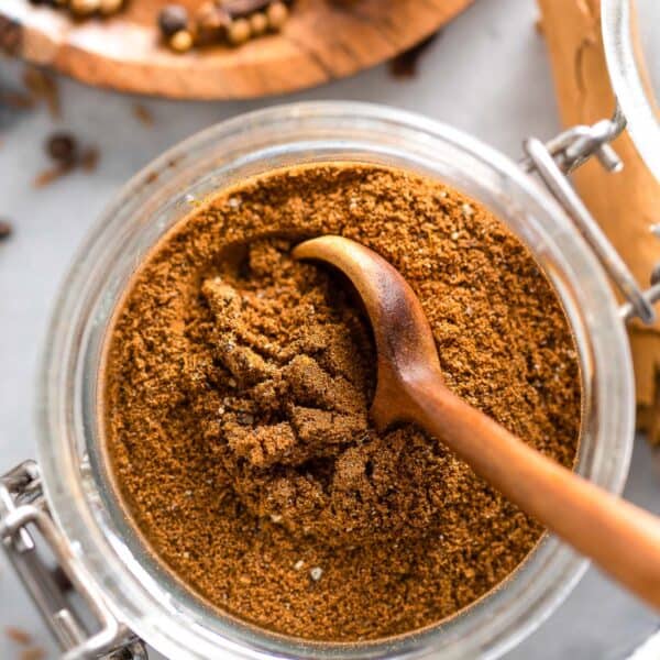 Lebanese Seven Spice in a spice jar with a spoon
