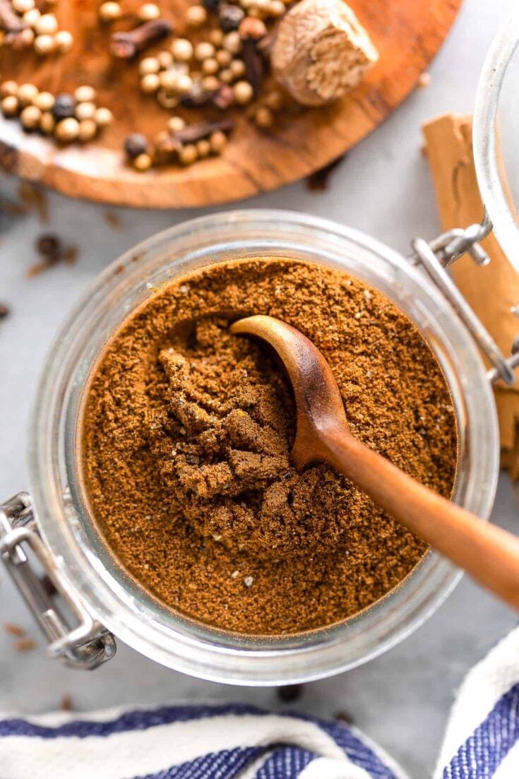 Lebanese Seven Spice in a spice jar with a spoon