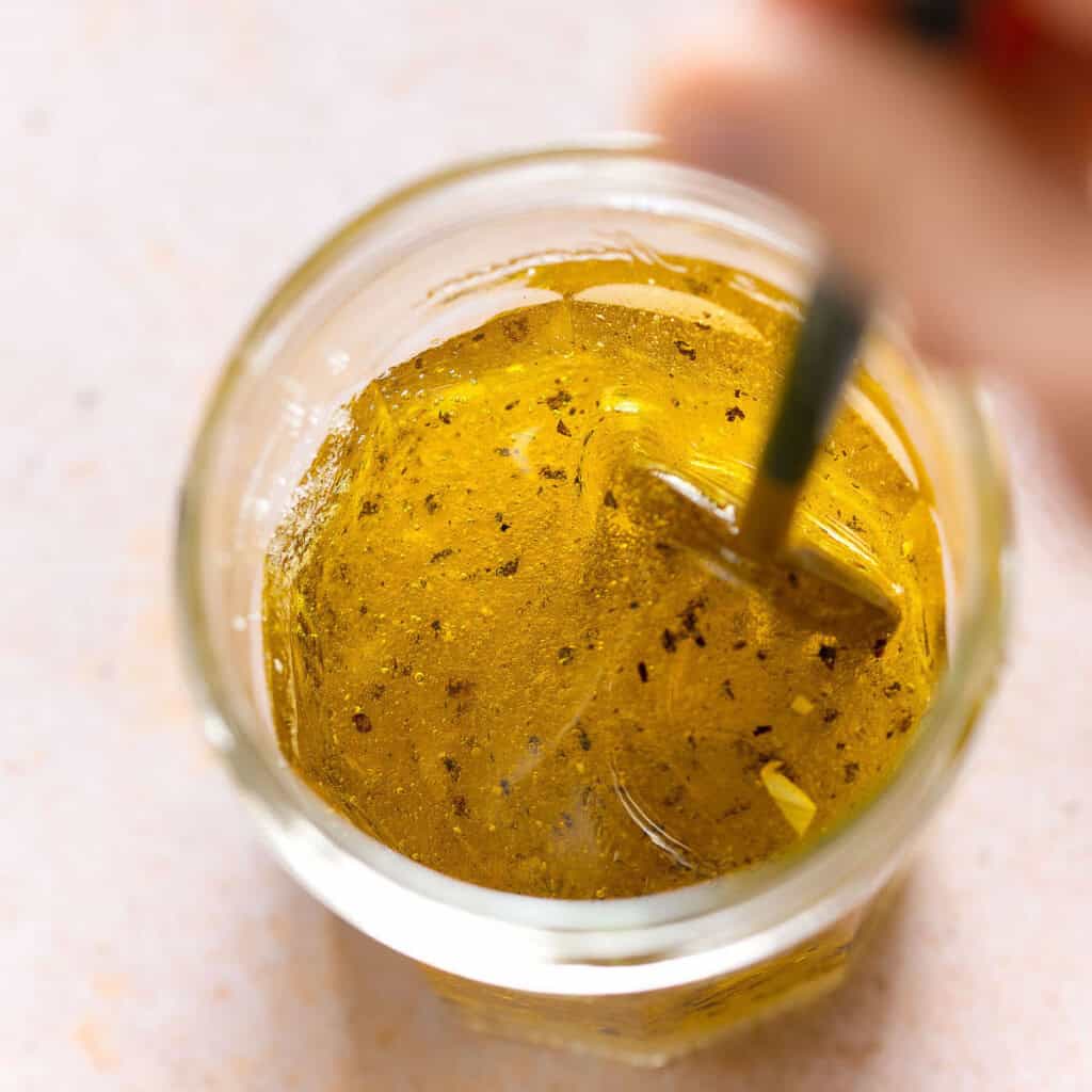 lemon and olive oil vinaigrette for a malfouf salad mixing together in a small jar