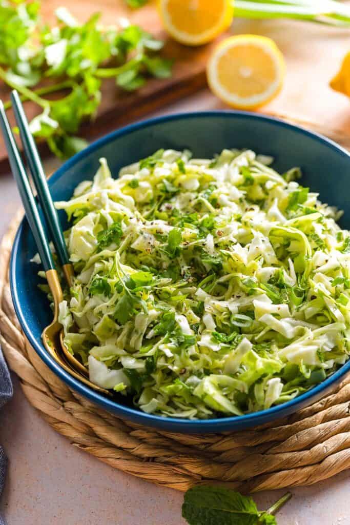 malfouf salad (lebanese cabbage slaw) in a salad bowl with a pair of serving forks 