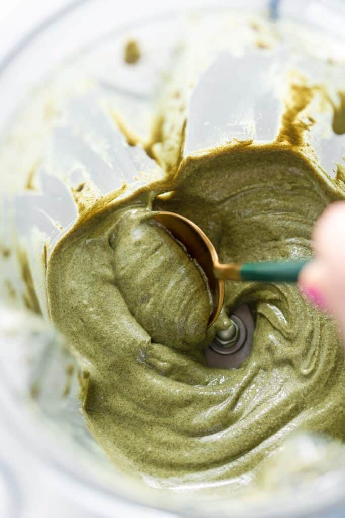a spoon stirring Homemade Pumpkin Seed Butter in a blender