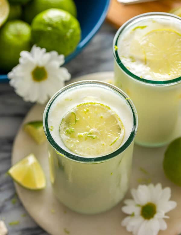 two glasses of Limonada Suíça also known as Brazilian Lemonade garnished with fresh lime slices