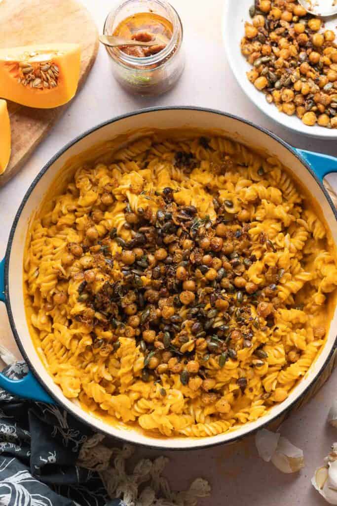 A pan full of Creamy Roasted Butternut Squash Pasta made with gluten free fusilli and topped with fried chickpeas and pumpkin seeds.
