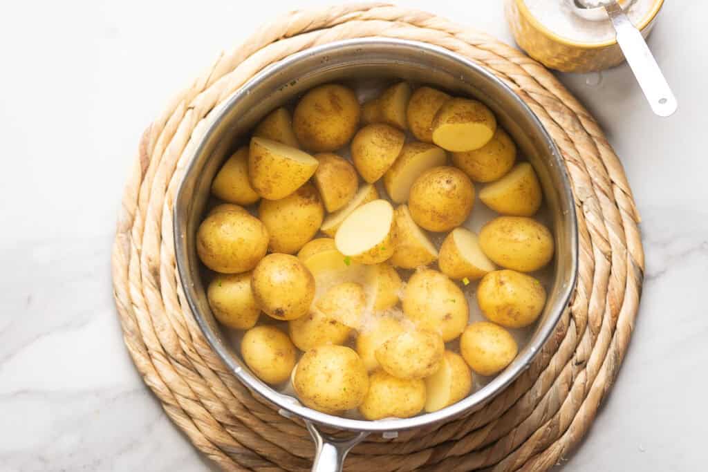 New potatoes covered in a pot of salted water to boil.