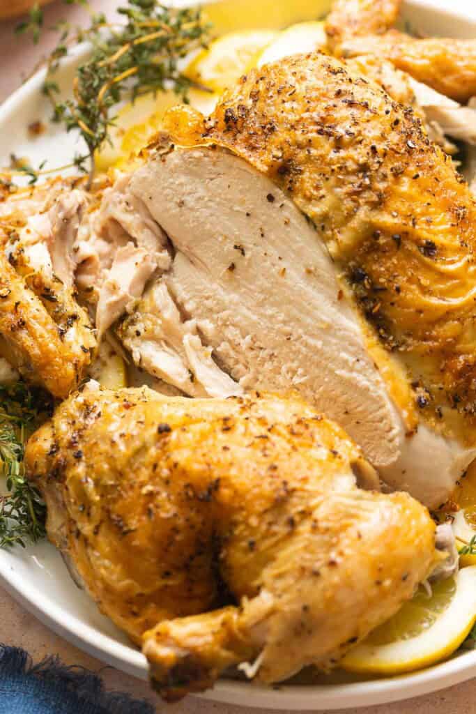 Roasted Spatchcocked Chicken on a plate with sliced missing from the breast.