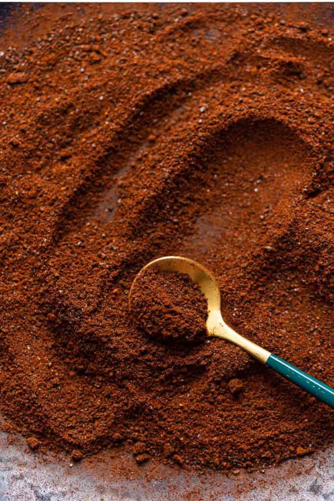 Ancho Chili Powder spread on a plate with a spoon.