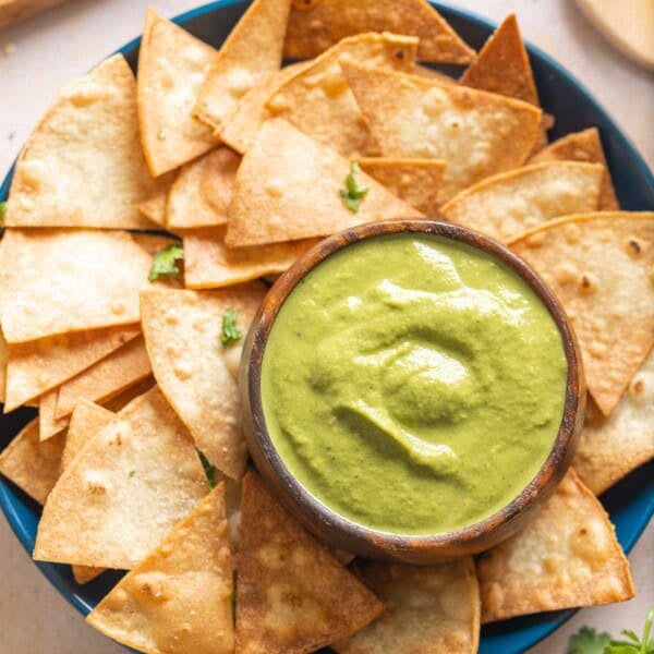Jalapeño Zucchini Salsa in a dip bowl on a plate with tortilla chips.