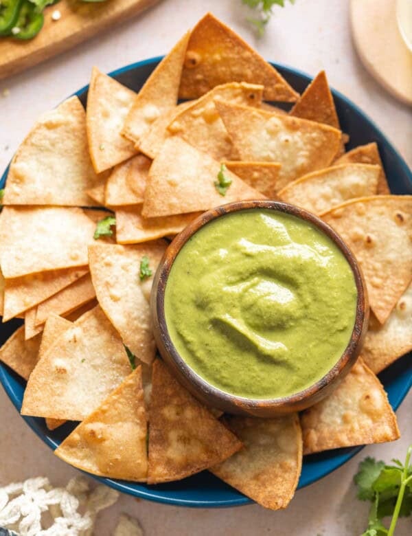 Jalapeño Zucchini Salsa in a dip bowl on a plate with tortilla chips.