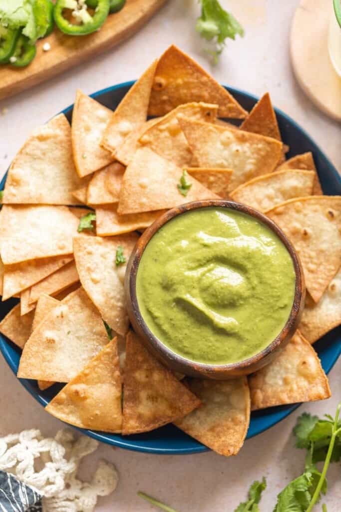 Jalapeño Zucchini Salsa  in a dip bowl on a plate with tortilla chips.