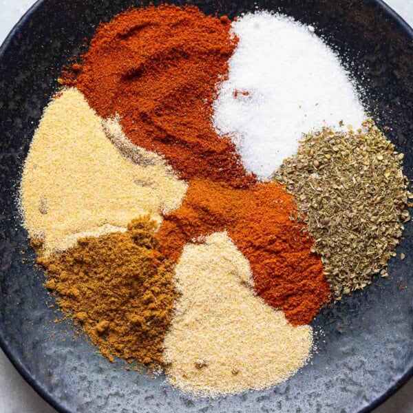 Homemade Taco Seasoning spices on a plate: chili powder, cumin, paprika, oregano, garlic powder, onion powder, salt and cayenne.