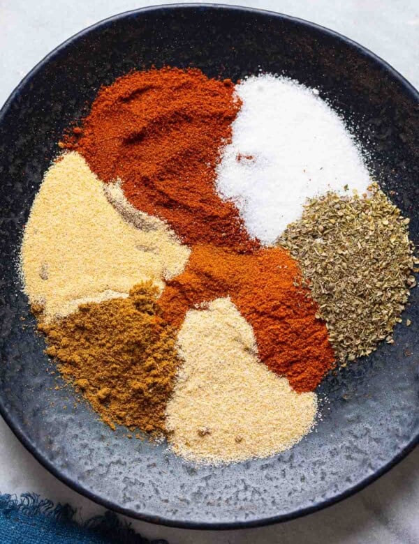 Homemade Taco Seasoning spices on a plate: chili powder, cumin, paprika, oregano, garlic powder, onion powder, salt and cayenne.
