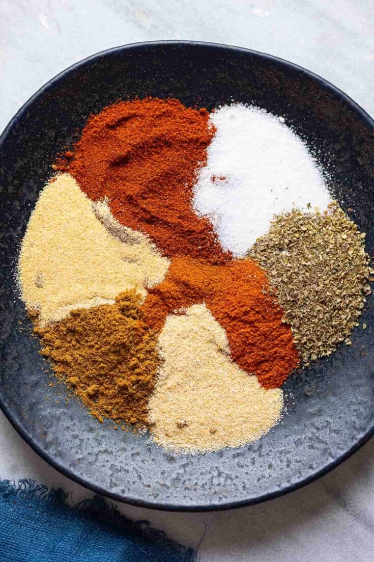 Homemade Taco Seasoning spices on a plate: chili powder, cumin, paprika, oregano, garlic powder, onion powder, salt and cayenne.