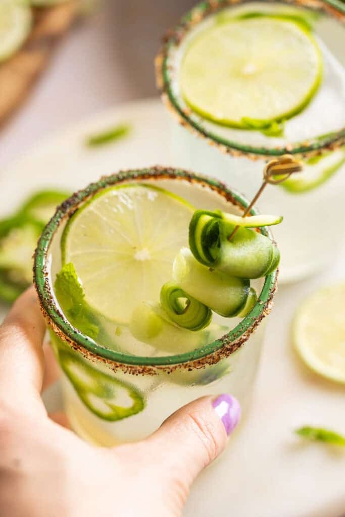 A hand grabbing a Jalapeño Cucumber Margarita
