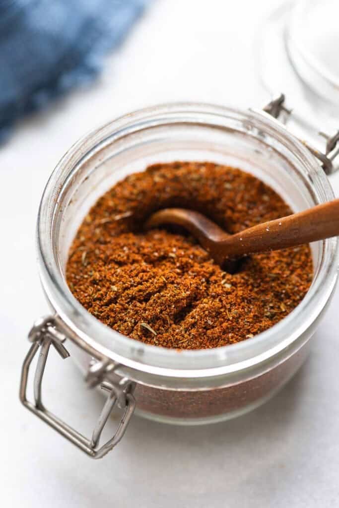 Low FODMAP Taco Seasoning mixed in a spice jar with a spoon.