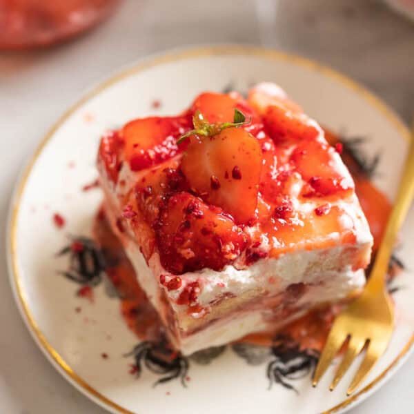 A slice of a Strawberry shortcake tiramisu on a cake plate with a fork.