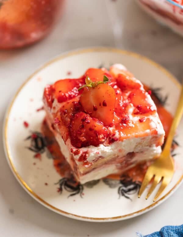 A slice of a Strawberry shortcake tiramisu on a cake plate with a fork.