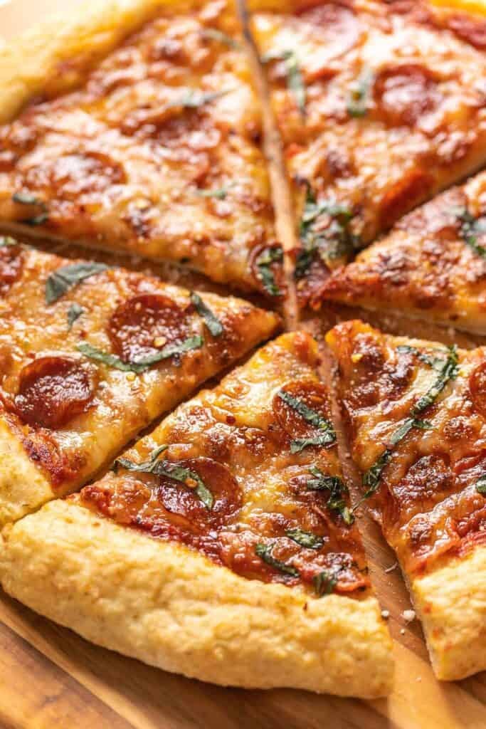 Homemade Gluten Free Pizza topped with cheese, pepperoni and fresh basil. 