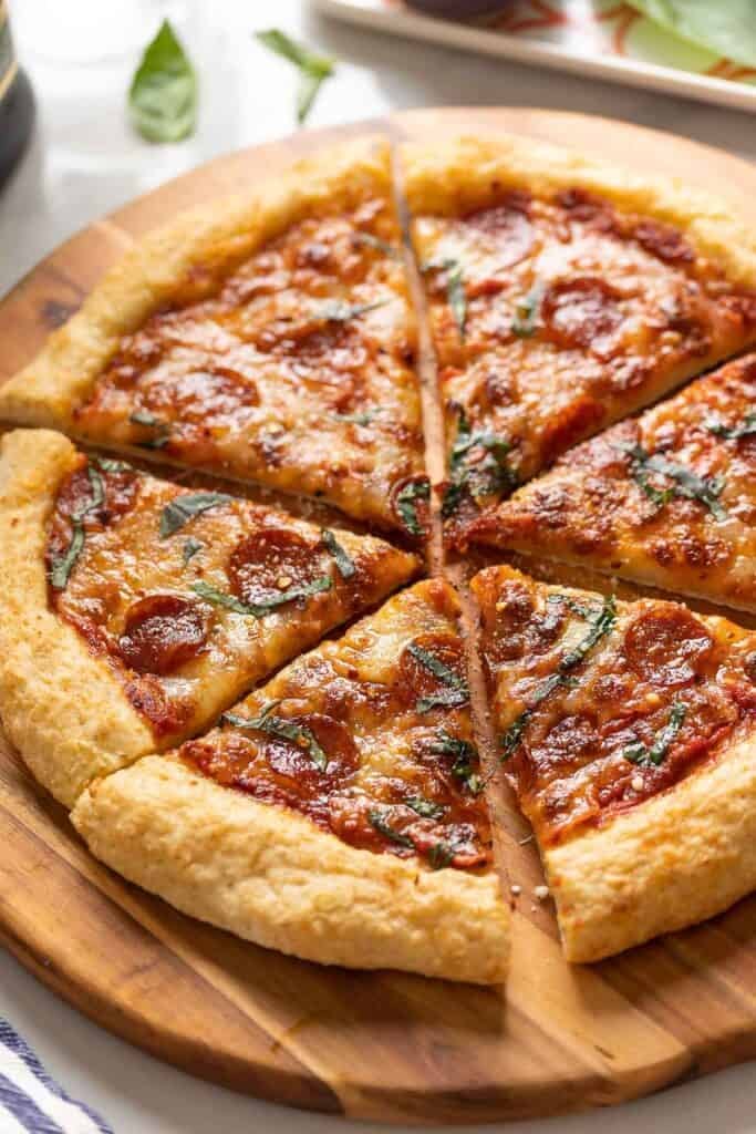 Homemade Gluten Free Pizza topped with cheese, pepperoni and fresh basil. 