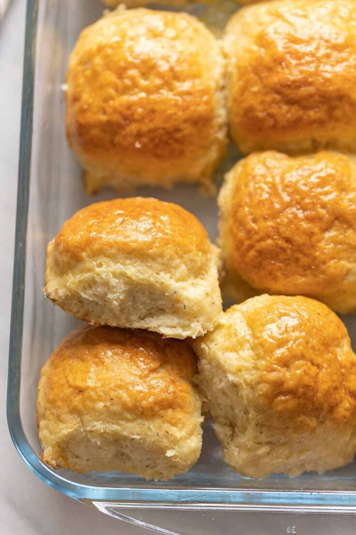 A baking dish filled with golden-brown gluten free dinner rolls, freshly baked and ready to serve.
